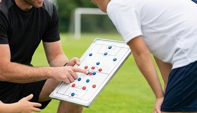 戦術ボードを使って説明するコーチ